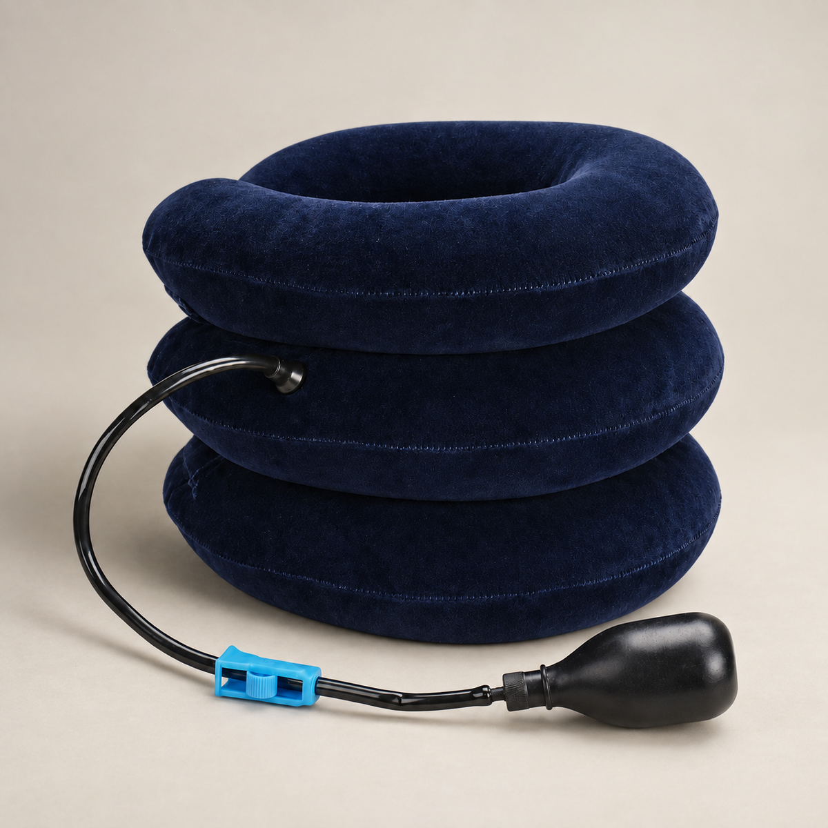 Rear view of the navy three-chamber inflatable collar with attached tube, blue clamp and hand pump.