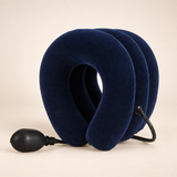 Side view of the navy inflatable neck collar showing its opening, three chambers and attached hand pump.