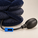 Close-up of the black hand pump, tube and blue clamp beside the navy collar fabric.
