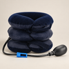 Navy three-chamber inflatable neck collar with hand pump and blue tube clamp on a cream studio background.