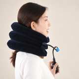 Side profile of a woman wearing the navy three-chamber inflatable neck collar and holding its black hand pump, showing how the collar fits around the neck.
